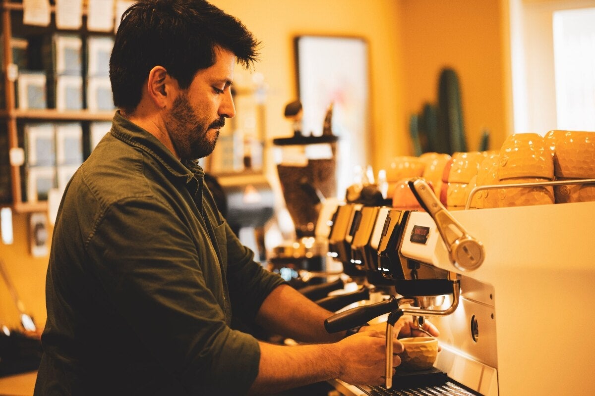 A man making coffee at Ciclos Café in Lima.