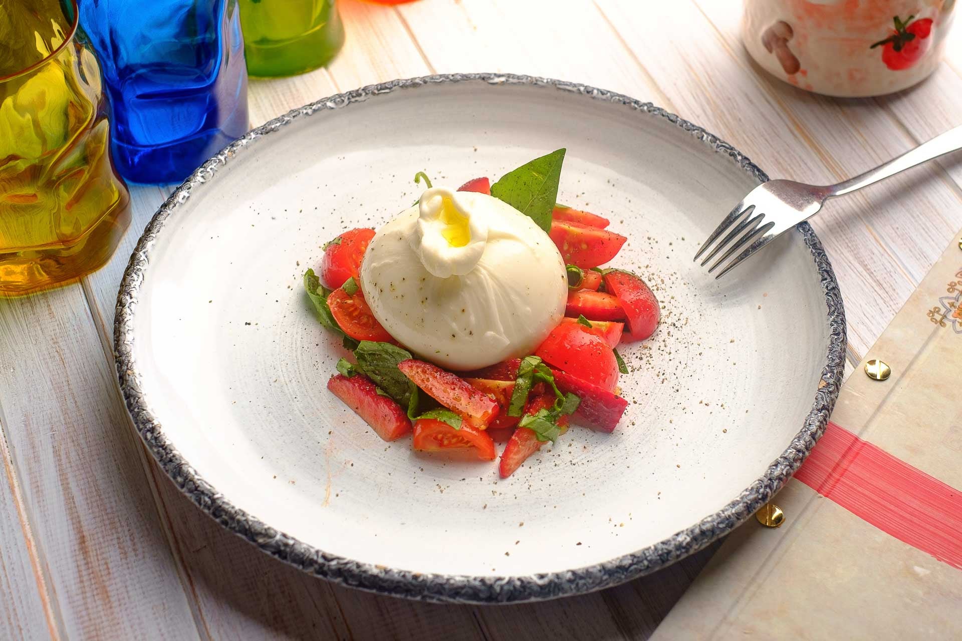 Burrata plated on top of fresh sliced strawberrries.