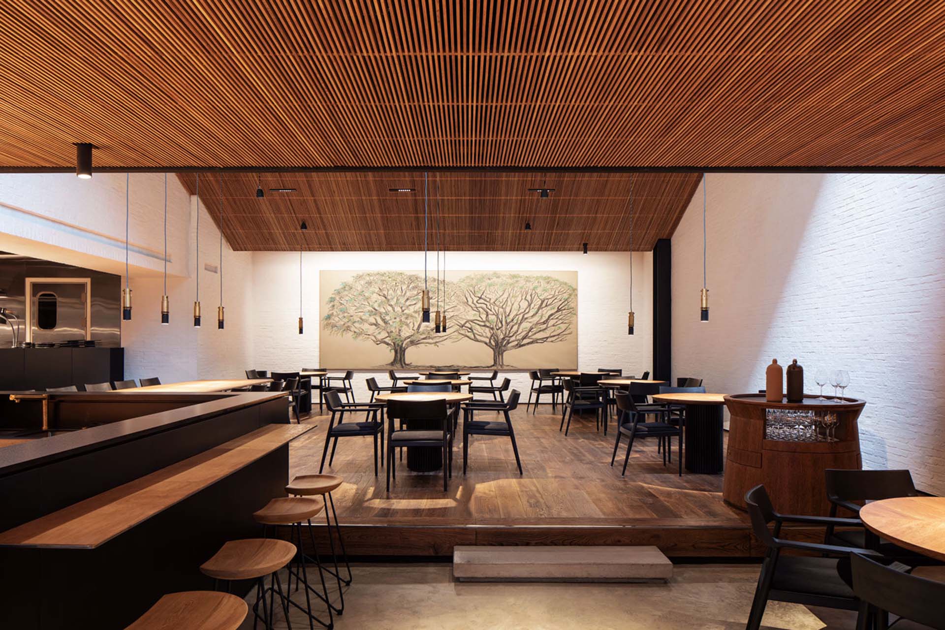An dining hall with a big canvas hanging on the wall picturing two trees
