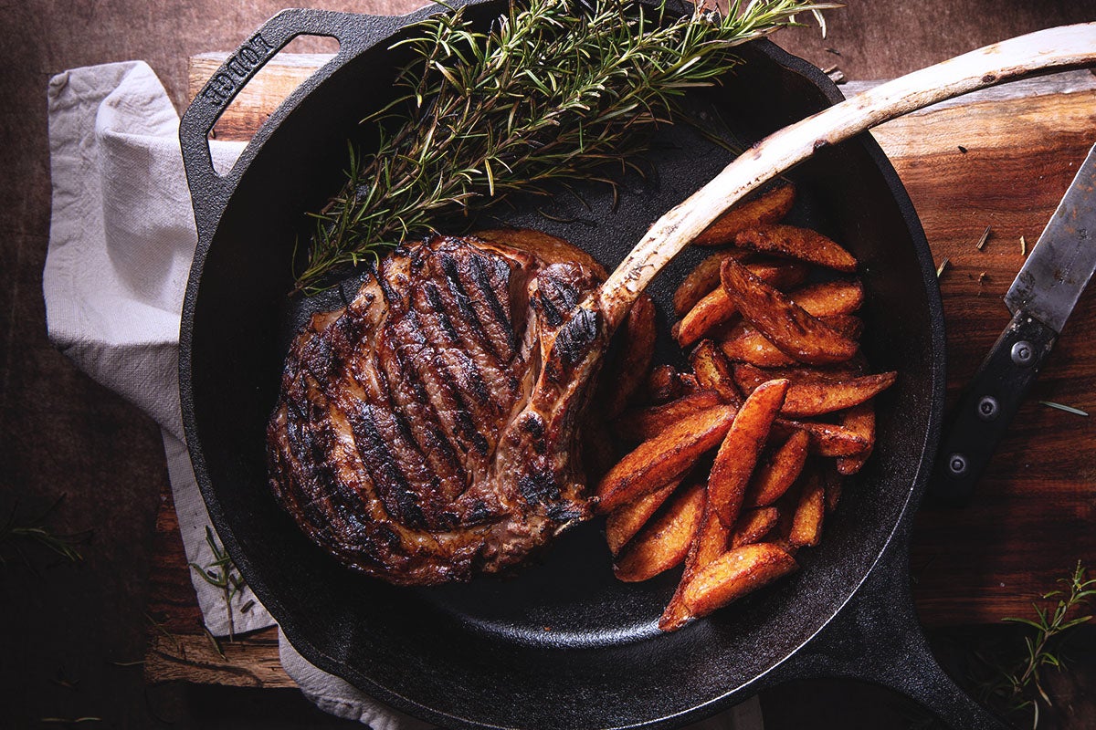Steak cooking in a pan.