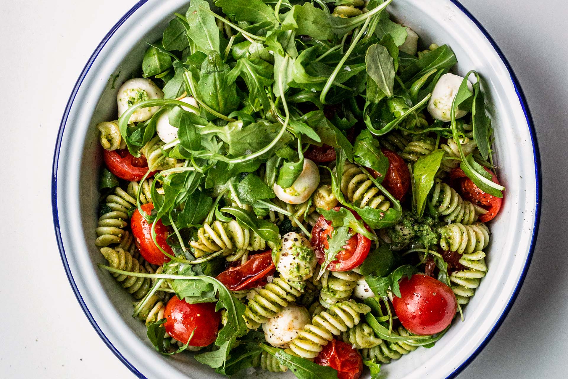 Pasta salad with pesto, arugula, tomatoes and mini mozzarella