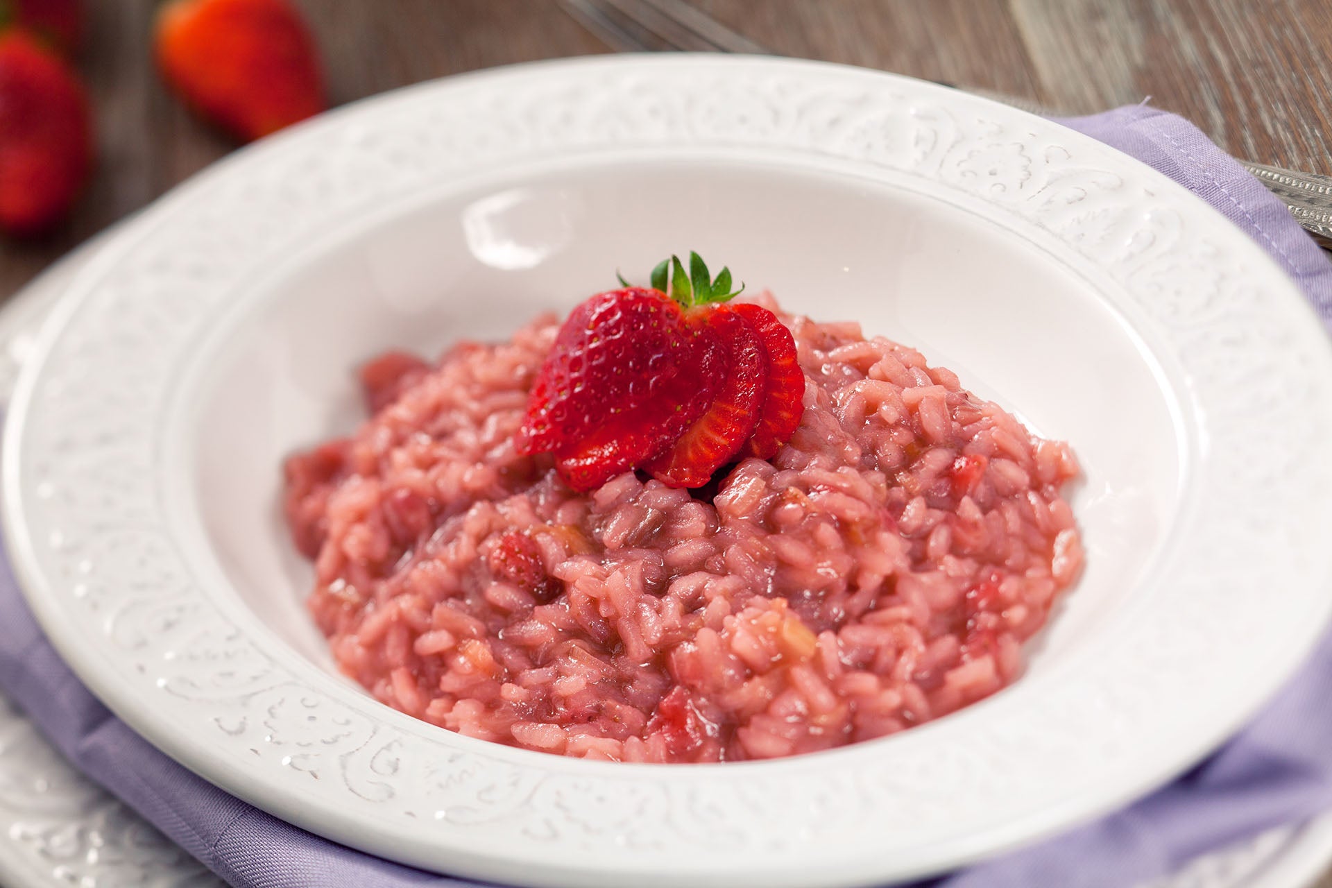 Strawberry risotto in a white bowl.