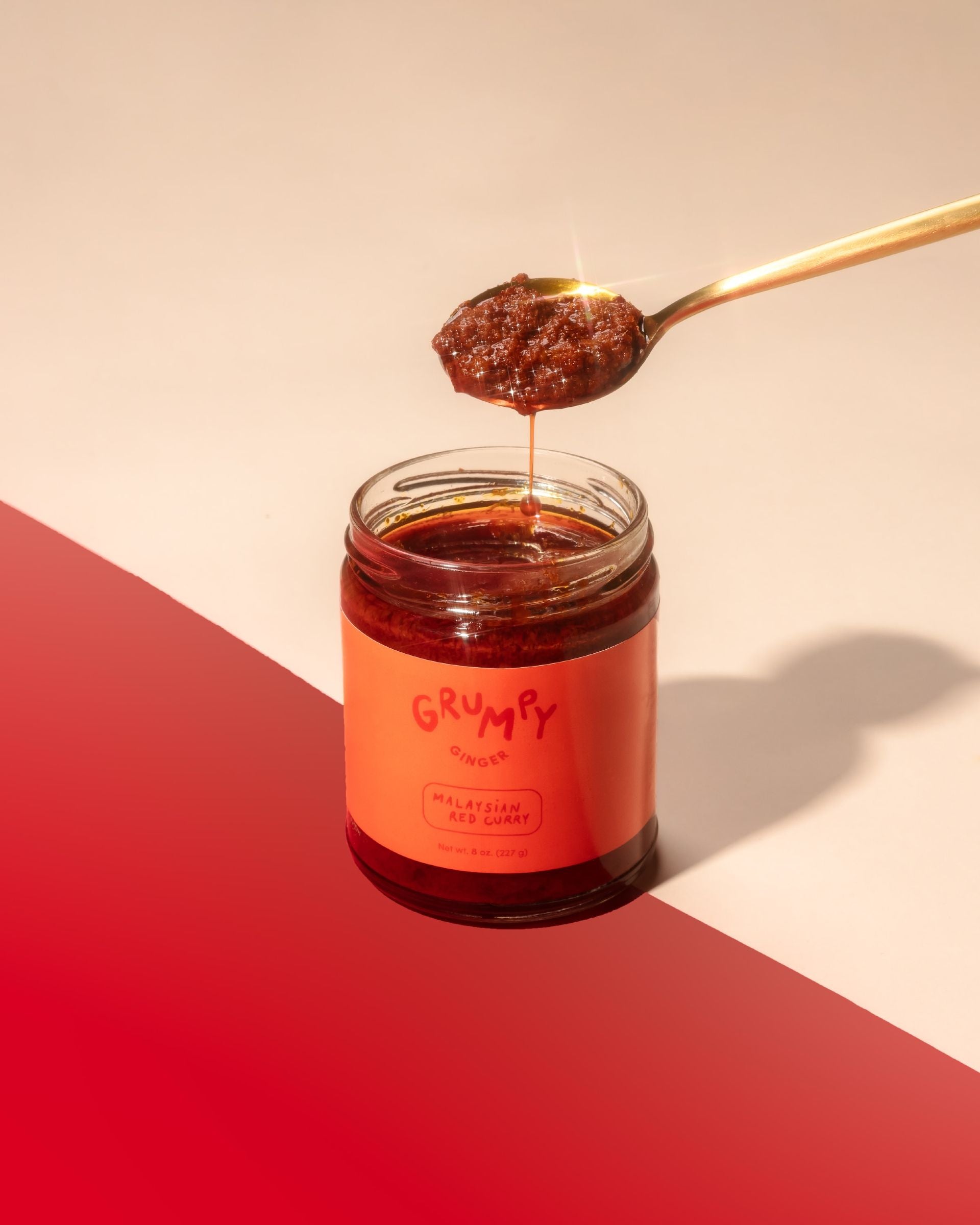 a jar of curry paste with a spoon