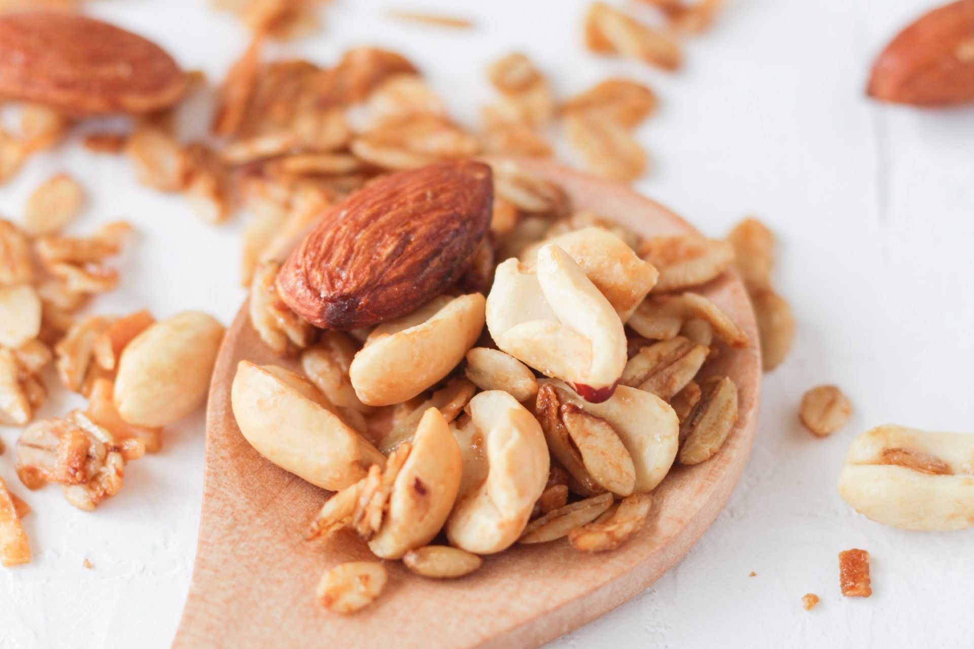 a wooden spoon holding a selection of nuts