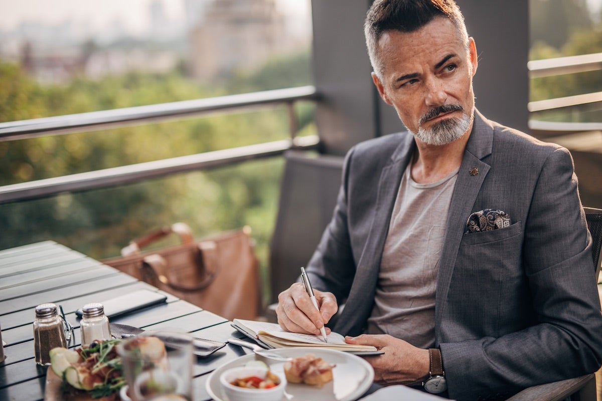 Man taking notes about meal as gastronomical critic