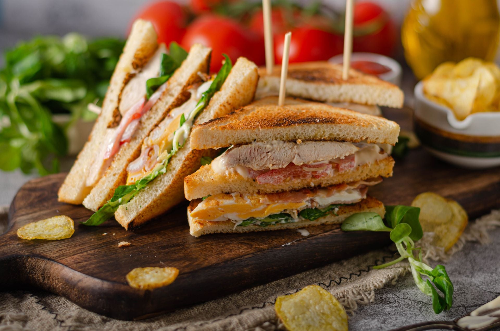 Chicken club sandwiches on a board.