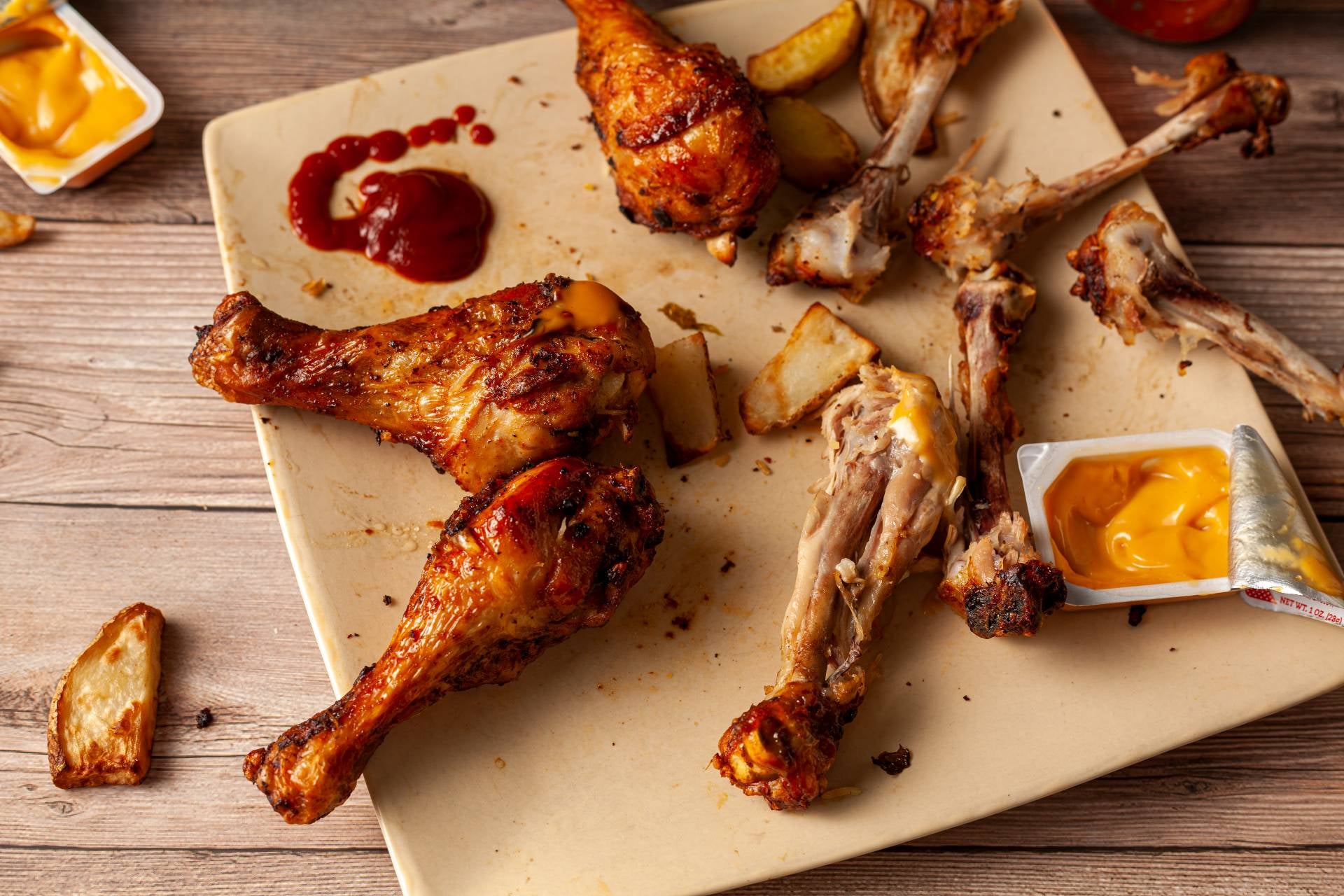 Half eaten chicken and dips.