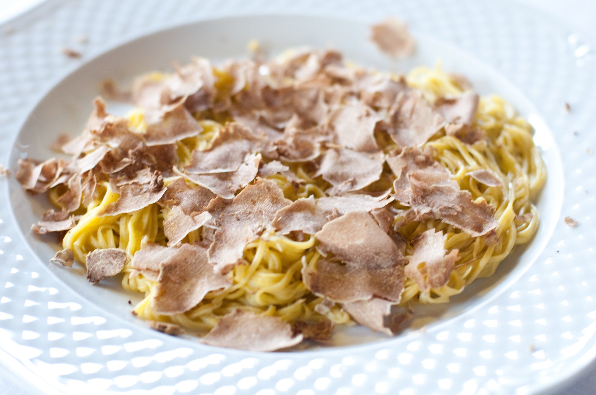 a bowl of pasta with shavings of white truffle