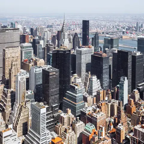 High-angle view of Manhattan’s dense skyline with prominent skyscrapers and the East River in the background