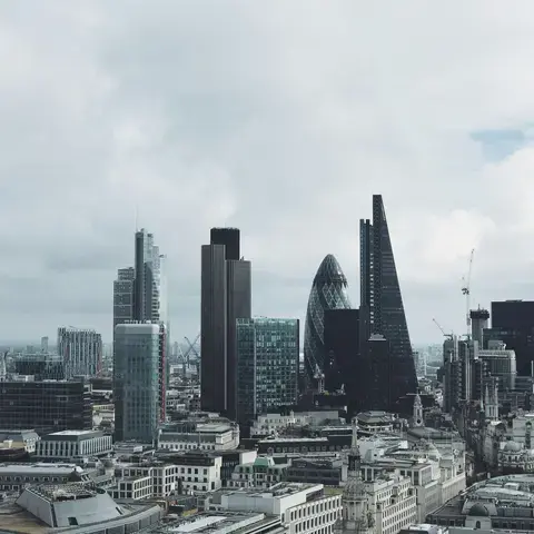 London’s iconic skyline with The Gherkin, The Cheesegrater, and modern skyscrapers rising under a cloudy sky