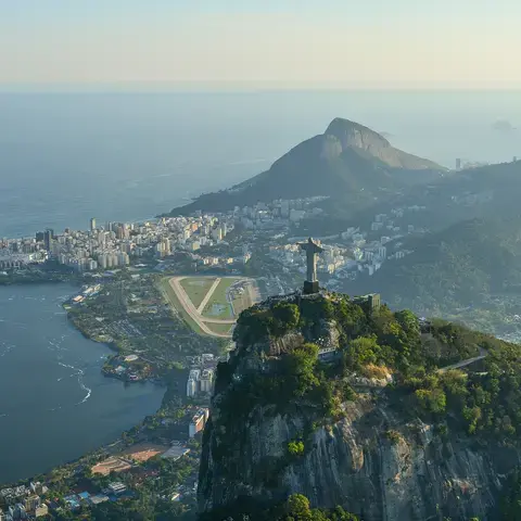 Iconic Christ the Redeemer statue overlooking Rio de Janeiro, Brazil, with views of mountains, city, and the Atlantic Ocean