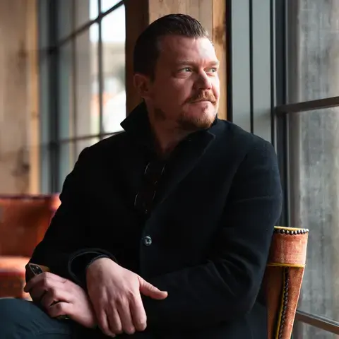 Chef Alex Dilling seated, looking out of a window.