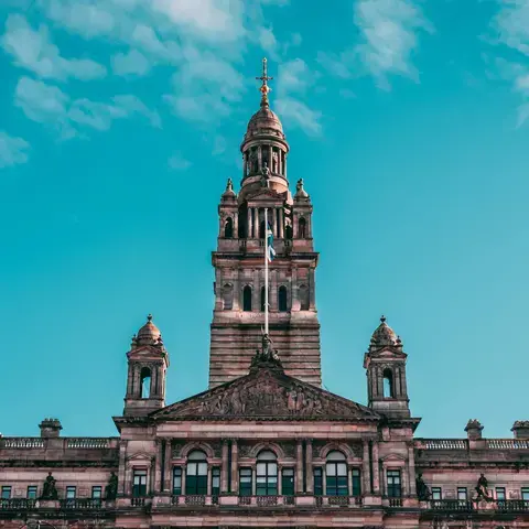 Ornate building with towers and sculptures, set against a bright blue sky, showcasing intricate architectural details