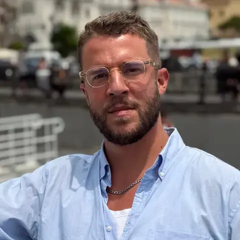 Jordon Ezra King in a blue shirt and glasses.
