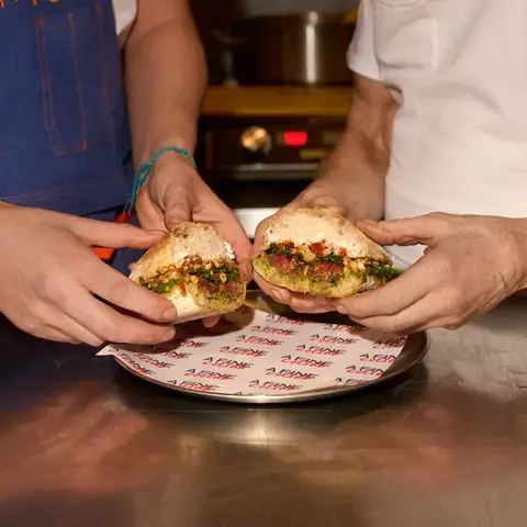 Two chefs holding the Fine Collab Sandwich in London.