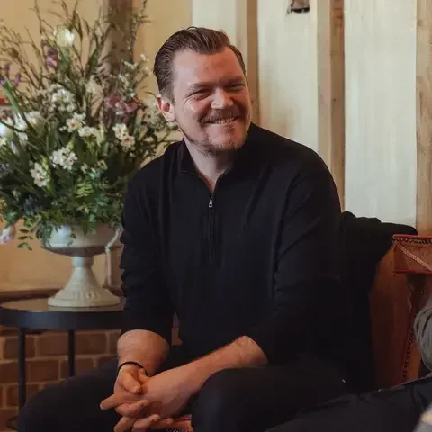 Chef Alex Dilling, seated and smiling in casual clothes.
