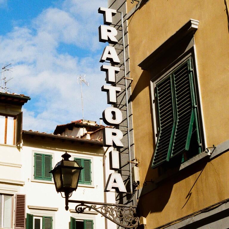 A trattoria sign on the side of a building.