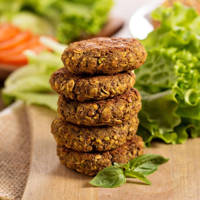 Stack of lentil burgers, with lettuce and tomatoes.