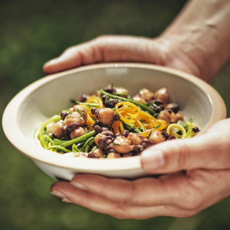 Someone holding a bowl of beans.