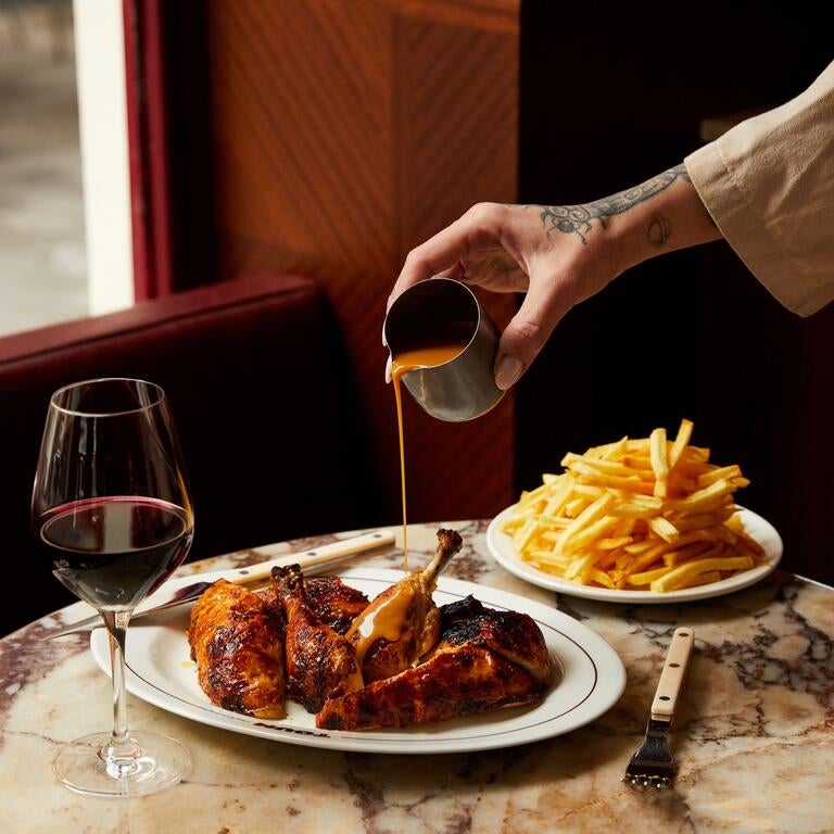 Pouring sauce on rotisserie chicken at Toum.