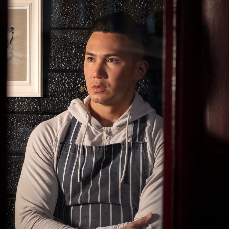 Chef Angelo Sato in an apron and hoodie.