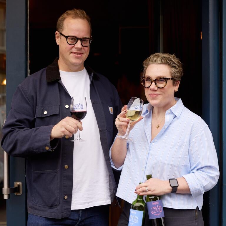 Pascal and Laura Wiedemann, holding glasses of wine.