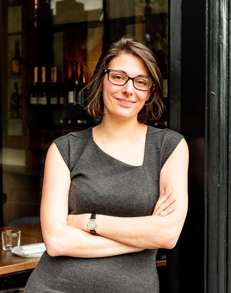 Alice Bussi with her arms folded outside a restaurant.