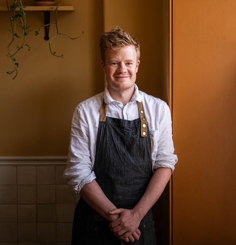 Chef Sam Lomas against an orange background.