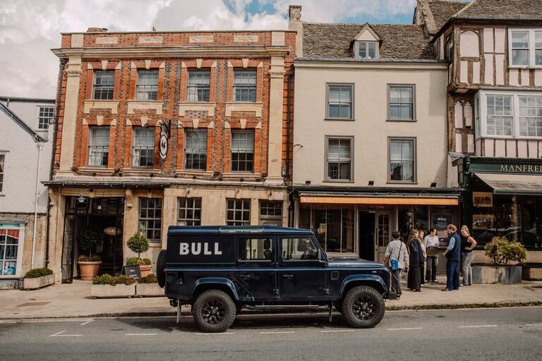 Exterior of Bull in Burford with a jeep in the foreground.