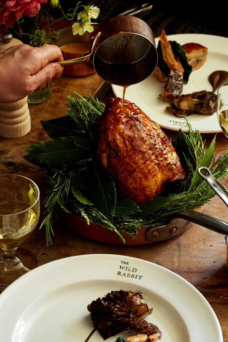 Sauce being poured over a roasted bird at The Wild Rabbit.