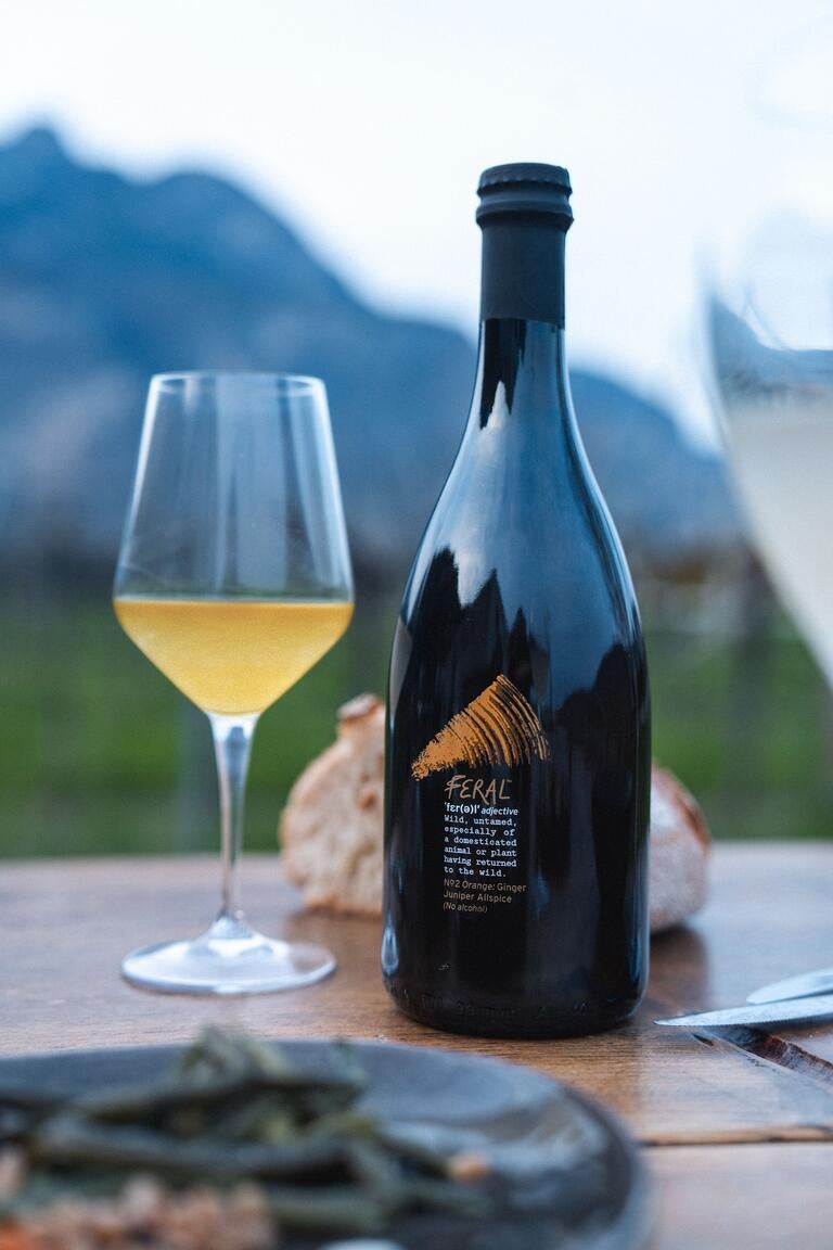 Bottle of Feral alongside a half-full wine glass.