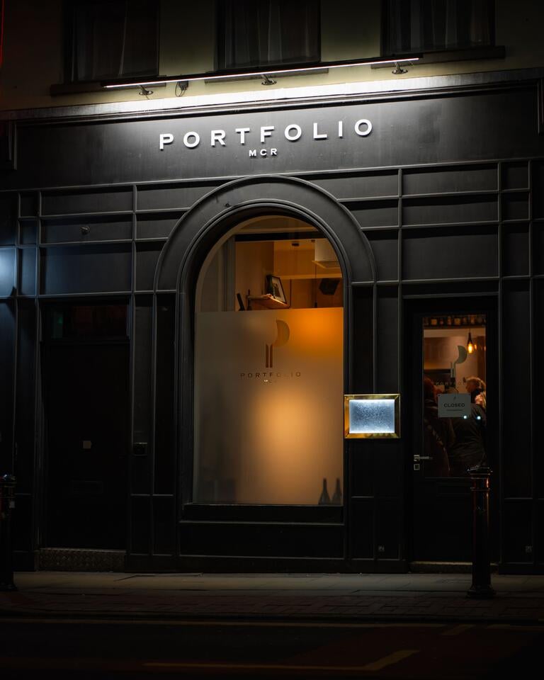Lit exterior of portfolio in Manchester at night.