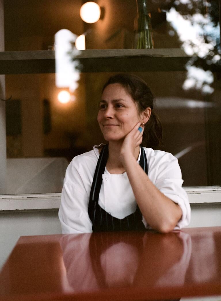 Chef Anna Tobias, seated in an apron.