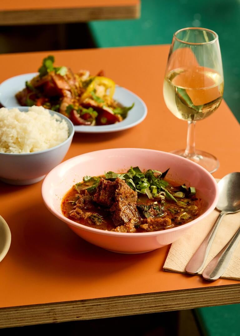 Dishes and wine on a table at Singburi in London.