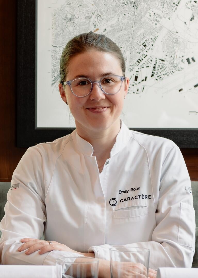 Emily Roux in a chef's jacket, smiling.