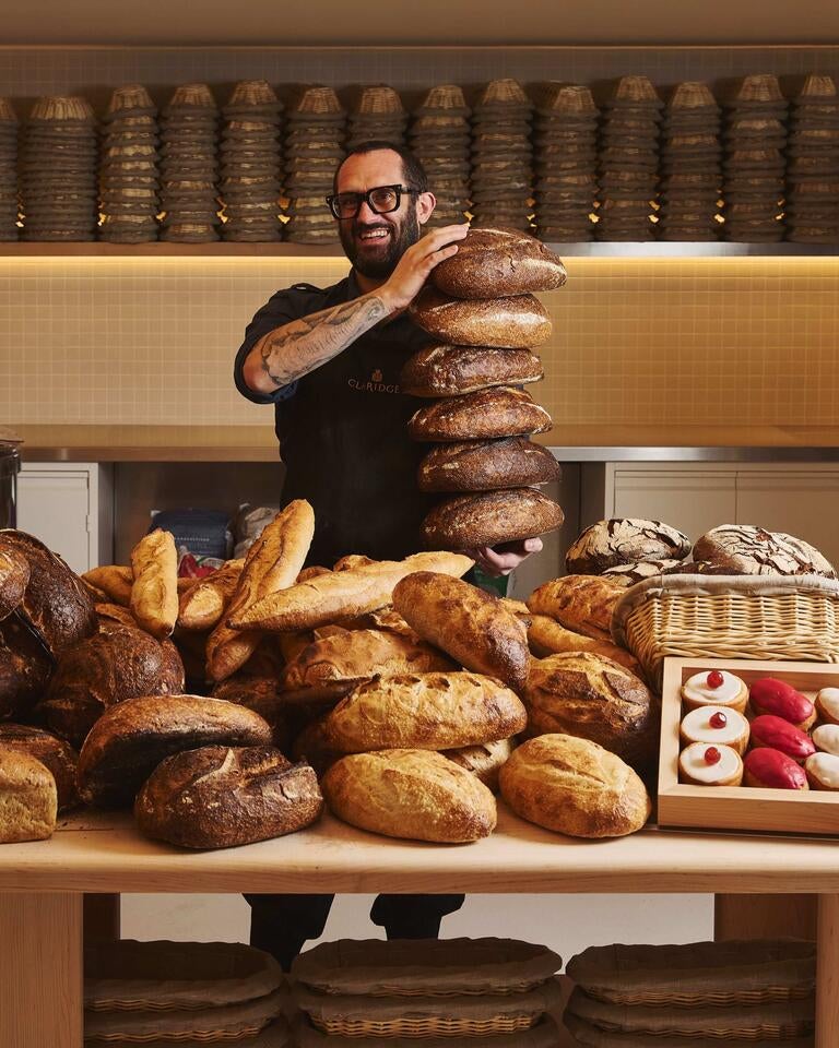 Richard Hart holding a tower of sourdough loaves.