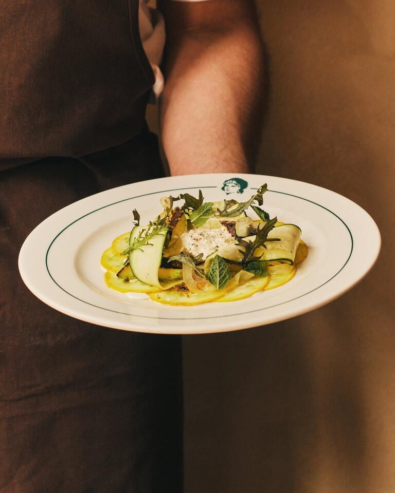 Someone holding a vegetable dish at Lita.