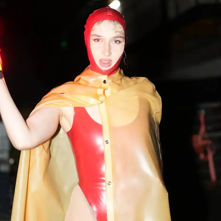 A performer at Diecast in a red swimming costume.