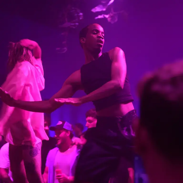 A performer bathed in purple light at Diecast.