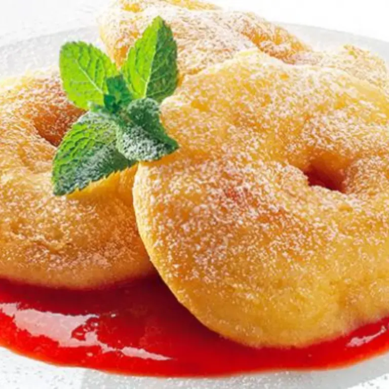 Fritelle atop a red sauce on a plate.