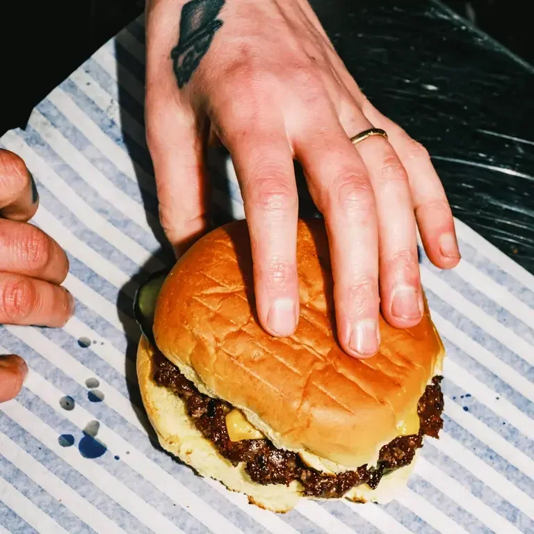 A hand holding a Jupiter burger.