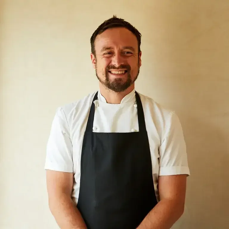 Chef Sam Carter smiling in an apron.