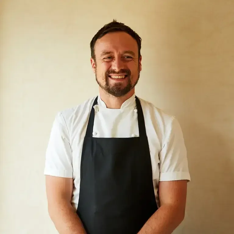 Chef Sam Carter smiling in an apron