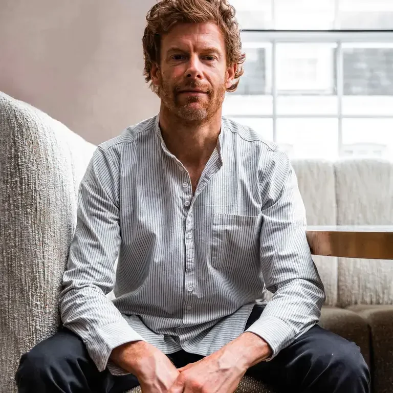 Chef Tom Aikens seated and dressed casually.