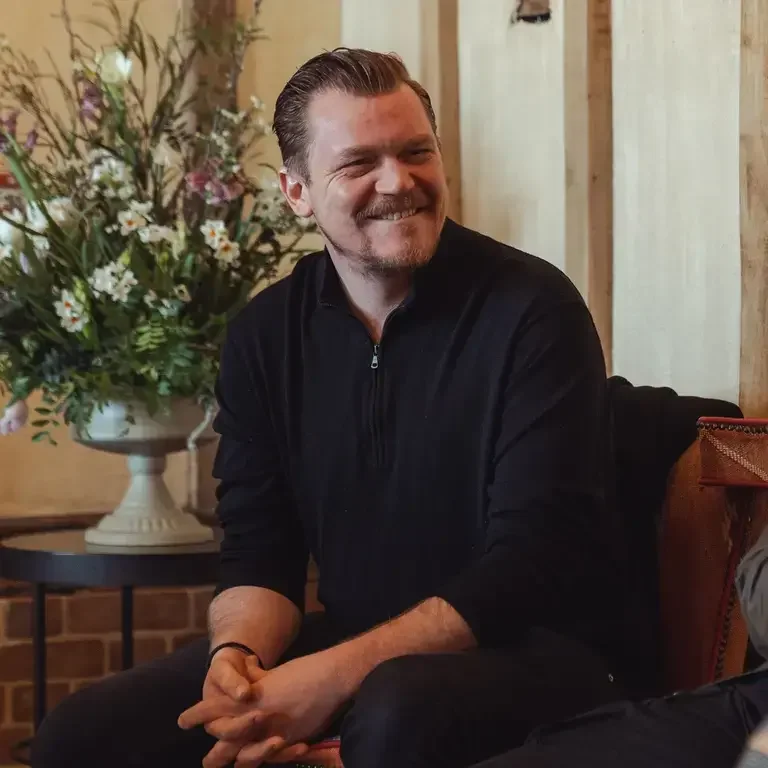 Chef Alex Dilling, seated and smiling in casual clothes.