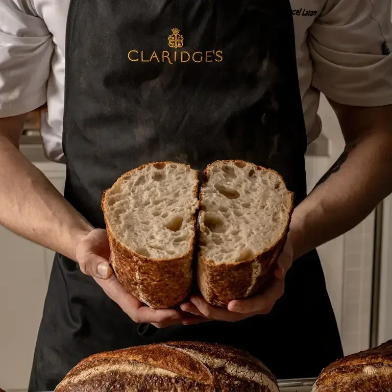 Someone holding a loaf of sourdough cut in two.