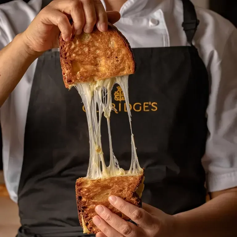 Someone pulling apart a toastie at Claridge's Bakery.