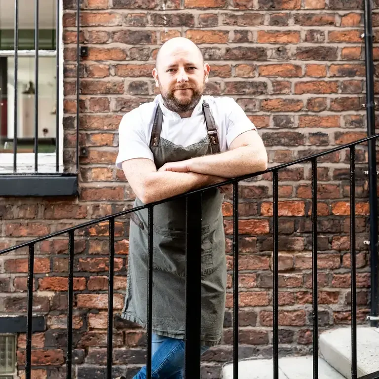 Chef Dan McGeorge leaning on a railing.