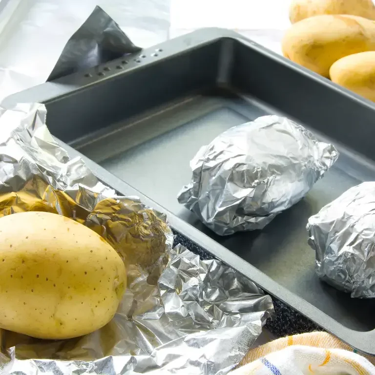 Baked potatoes wrapped in aluminium foil