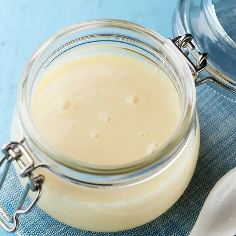 Condensed milk in a glass jar.